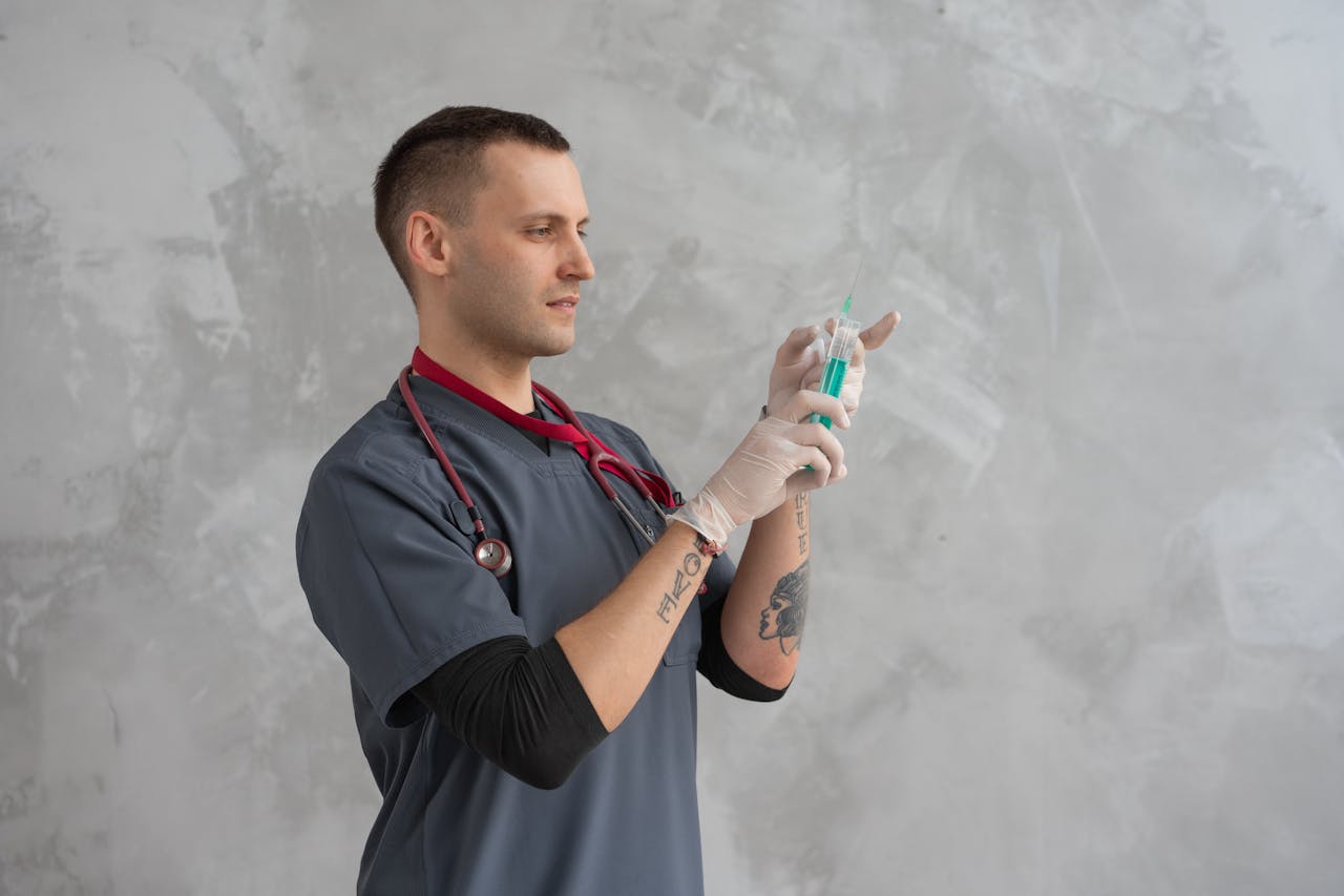 Male healthcare worker preparing syringe with focus and precision.